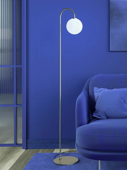 skandinavische Stehleuchte Herstal Lampe Ballon Floor in Messing neben Couch Wohnzimmer Beleuchtung